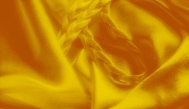 Pürüzsüz sarı kumaştan ince örgüler, lüks ve zarif bir doku yaratıyor. Saten benzeri kumaş ve yumuşak kıvrımlar kumaşın genel zenginliğini arttırır..