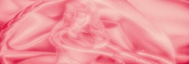 Yumuşak kıvrımlar arasında karmaşık bir şekilde örülmüş ipeksi pembe kumaş bulanıklığı dalgaların ve ayrıntılı örgülerin karışımını oluşturuyor. Doku zarafet ve lüks yayar..