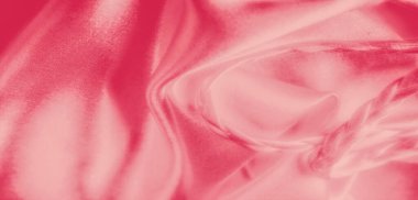 Yumuşak örgü örülmüş pembe saten kumaş bulanıklığı hassas ve zarif bir düzenleme oluşturuyor. Işık, kumaşın yumuşak ve lüks dokusunu geliştirmek için nazikçe çalar..