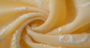 Görüntü, beyaz kıvrımlı işlemeli, karmaşık bir şekilde işlemeli sarı kumaş. Kumaşın yumuşak kıvrımları ve dokusu kalitesini gösteriyor, onu el işi veya moda için mükemmel yapıyor..