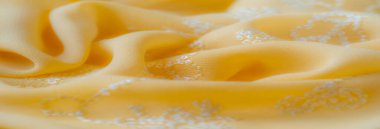 Bulanık - Yumuşak kıvrımlı sarı kumaş ve karmaşık beyaz çiçekli nakış zarafet ve cazibe ekler. Hassas girdaplar ve detaylı dikişler bu tekstili sanatsal açıdan mükemmel kılıyor.