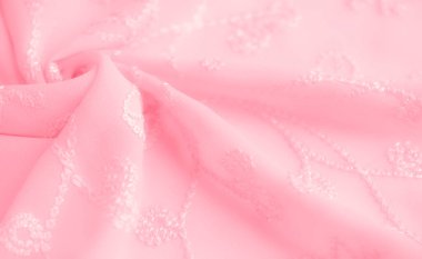 Detaylı nakışlı pembe bir kumaş, yumuşakça örtülmüş ve davetkar ve lüks bir doku yaratıyor. İşlemeli desenler kumaşla zarif bir şekilde harmanlanmış.