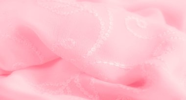 Karmaşık çiçek işlemeli pembe kumaş bulanıklığı. Yumuşak, akışkan kıvrımlar kumaşın dokusunu ve lüks görünümünü vurgular..