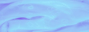 Görüntü. Bu mavi kumaş narin çiçek işlemelerinden ve pürüzsüz, akan kıvrımlardan oluşur. Karmaşık dikişler yumuşak, ışıltılı maddeye bir dokunuş ekleyerek rüya gibi bir madde yaratıyor.,