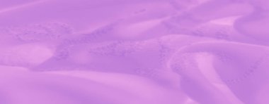 Yumuşak kıvrımlı, narin mor kumaş ve karmaşık detaylar. Kumaşın pürüzsüz dokusu ve akışkan tasarımı görsel olarak rahatlatıcı ve zarif bir estetik yaratıyor..