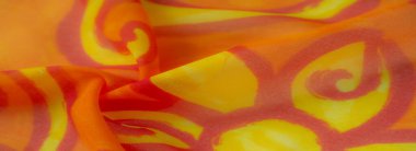 Sarı kıvrımlı parlak turuncu kumaşlı. Kumaşın pürüzsüz kıvrımları ışığı yakalayarak, dekoratif kullanım için ideal, zengin tonlar ve dokularla dinamik bir kompozisyon oluşturuyor..