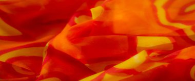 Ilık turuncu ve sarı kumaşlı sıvı girdap desenli bulanık. Kumaşın kıvrımları dinamik bir akış yaratıyor. Yumuşak tekstil enerjisinden sıcaklık ve enerji yayıyor..