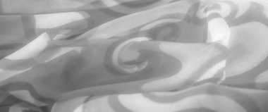 Gri tonlu kumaşı soyut ve akışkan desenlerle bulanıklaştır. Dönen şekiller yumuşak kıvrımlara hafifçe vurgulanıyor ve modern tekstil için hassas bir doku ve tasarım dengesi yaratıyor.