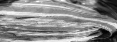 Kalıpların karmaşıklığını vurgulamak için gümüş ve beyaz çizgili siyah kumaş bulanıklığı. Katlar, akan kumaşa derinlik ve incelik ekler..