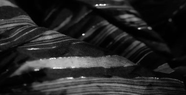 Görüntü, ince dikey çizgili yumuşak siyah kumaş. Parlak bir etki yaratmak için karmaşık bir şekilde örülmüş. Katlar derinlik ve sanatsal bir ışık ve gölge oyunu yaratır..