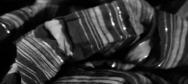 Bulanık, zarif dikey çizgileri olan yumuşak kumaş. Karmaşık kıvrımlarla ışığı yakalıyor. Siyah ve beyaz tonlar, modern moda ve tasarım için mükemmel, pürüzsüz, parıldayan bir doku yaratır..