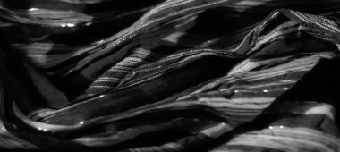 Görüntü, parlak dikey çizgileri olan zarif siyah kumaş, dinamik bir tasarım yaratmak için karmaşık bir şekilde örülmüş. Yumuşak kıvrımlar ışık yansımasını güçlendirir, derinlik ve lüks bir his ekler..