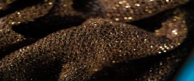 Yumuşak, pürüzsüz kıvrımları ve parlak bir yüzeyi olan zengin, parlak, koyu renkli bir kumaş. Görüntü lüks dokuyu ön plana çıkarıyor, tasarım ve moda için ideal hale getiriyor.