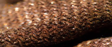 Parlak röfleli koyu renk kumaş bulanıklığı, hafif bir parıltı etkisi. Doku yumuşak ama yapılandırılmış görünüyor, küçük ışık zerreleri maddeye boyut ve derinlik katıyor..