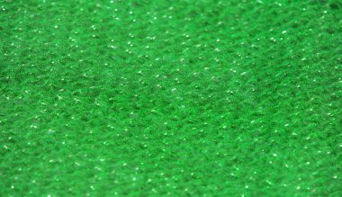 Parıldayan ipliklerle örülmüş koyu yeşil kumaş ışığı yakalıyor. Kumaşın zengin dokusu ve kıvrımları lüks bir derinlik ekler, moda ve tasarım uygulamaları için mükemmeldir.