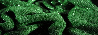 Parıldayan parçacıklar serpiştirilmiş koyu yeşil kumaş bulanıklığı, tekstil geçmişi ve moda materyali uygulamaları için detaylı ve ışıltılı bir yüzey sunuyor..