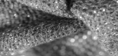 Karmaşık dokusu ve yumuşak kıvrımları olan parlak siyah kumaş bulanıklığı. Yüzeydeki ışık oyunu lüks ve zarif bir görünüm yaratıyor, moda, tekstil veya soyut tasarım temaları için ideal..