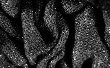 Işıl ışıl yüzeyi olan parlak siyah kumaşın bulanık görüntüsü. Karmaşık doku ve parlak iplikler moda veya tasarım için mükemmel, zarif ve lüks bir his yaratır..