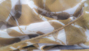 Havadar, şeffaf kumaş, kahverengi yaprak benzeri desenler, nazikçe katlanmış ve katmanlanmış, yumuşak, doğal bir görünüm sunuyor, toprak tonlarını hassas bir dokunuşla harmanlıyor..