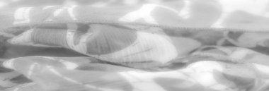 Karmaşık soyut desenlere sahip bulanık beyaz kumaş, yumuşak kıvrımları ve pürüzsüz dokuları vurguluyor. Kumaşın hafif hava kalitesi ve ince gölgeler sakin ve sakinleştirici bir atmosfer yaratıyor.