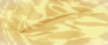 Karmaşık, soyut desenli bulanık sarı kumaş yumuşak ve dağınık ışıkta yavaşça akar. Katlar ve şekiller, kumaşın hassas dokusunu vurgulayarak barışçıl ve yatıştırıcı bir görsel yaratıyor..