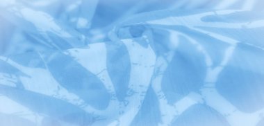 Soyut şekilli bulanık mavi ve beyaz kumaş kıvrılarak yumuşak kıvrımlara dönüşür. Kumaşın akışkan hareketi ve dingin tasarımı ona hafif, ruhani ve sanatsal tekstil için ideal bir kalite verir..