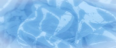 Bulanık soyut desenler mavi kumaş boyunca akar, yumuşak dalgalanmalar ve yumuşak, sakin bir doku yaratır. Açık mavi renkler ve akan şekiller modern ve rahatlatıcı estetiğini geliştirir..