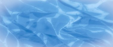 Bulanık, bu görüntü dalgalı üzengisel desenli mavi kumaş kıvrımlarını ortaya çıkarıyor. Pürüzsüz, akıcı dokular ve soyut şekiller kumaşa dinamik ve dinamik bir görünüm verir.