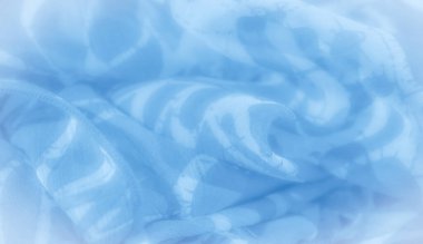 Mavi bir kumaşın bulanıklığı, soyut, organik şekiller, yumuşak beyaz tonlarda. Kumaşın dalgalı dokusu ve havadar hissi tasarıma ruhani ve aydınlık bir görünüm verir..