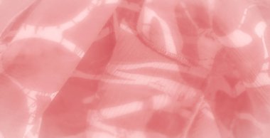 Yumuşak dalgalar ve nazik kıvrımlarla hareket halindeki pembe kumaşın bulanık görüntüsü sanatsal, rüya gibi bir görsel yaratıyor. Hassas madde ışığı ve gölgeyi yakalar ve tasarıma derinlik ve boyut ekler.