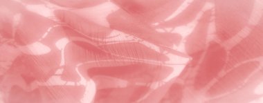 Yumuşak, şeffaf pembe kumaş soyut yaprakları anımsatan bir desen içeriyor. Işık maddenin içinden süzülür, huzurlu ve akışkan bir görsel etki yaratır..