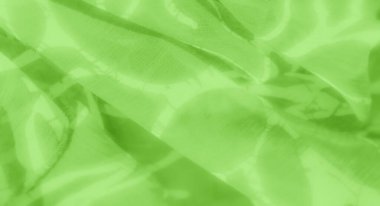 Üst üste binen yeşil renkleri ve ince desenli deseni olan bulanık bir kumaş. Yumuşak kıvrımlar ve dalgalanan yüzey sanatsal bir derinlik yaratır, kumaşların görsel çekiciliğini arttırır..