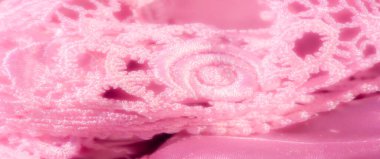 İpeksi pembe saten kumaşın üzerindeki karmaşık dantelli bulanıklık. Dantel tasarımı pürüzsüz satene romantik bir dokunuş katıyor. Bu da onu mükemmel bir doku ve zarafet kombinasyonu yapıyor..