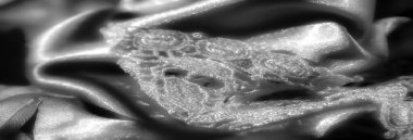 Bu resim saten kumaşın yumuşak, akışkan kıvrımlarını vurgular, zarif bir kompozisyon yaratır. Kumaşlar ışığın altında hafif dalgalar parıldıyor, ona lüks ve pürüzsüz bir doku veriyor..