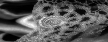 Görüntü - Parıldayan siyah-beyaz saten kumaşlar ışığı zarifçe yansıtarak zarif ve lüks bir görünüm yaratıyor. Yumuşak doku ve yumuşak kırışıklıklar derinlik ve karmaşıklık ekler..