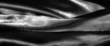 pürüzsüz, parlak bir kumaşın siyah bulanıklığı yumuşak, ruhani bir parıltıyla ışığı yansıtan karmaşık bir şekilde katlanır. İpeksi dokusu ona zarif ve lüks bir his veriyor. Üst düzey tasarımlar için mükemmel..