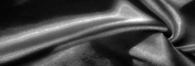 İpek kumaş yumuşak kıvrımlar ve yumuşak dokularla akar, ışık ve gölgenin etkileşimini güzel bir şekilde yakalar. Monokromatik palet onun rafine ve dokunsal çekiciliğine eklenir.