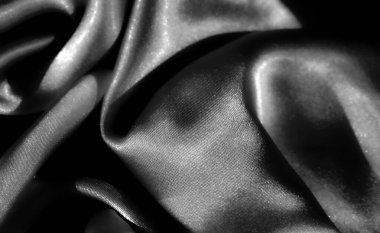 Siyah bulanık kumaş gri tonda katlanır, pürüzsüz, parlak yüzeyi ve karmaşık örtüyü vurgular. Zarif, lüks dokusu sanatsal amaçlar için soyut ve sofistike bir görüntü yaratıyor.