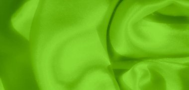 Yumuşak, pürüzsüz kıvrımlarla kaplanmış parlak yeşil saten kumaştan bulanık, parlak, parlak bir kaplama ile parlak ve parlak bir yüzey oluşturarak ipeksi dokusunu ön plana çıkarıyor..