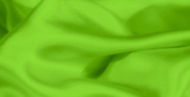 Yumuşak, akışkan kıvrımlara sarılı parlak yeşil saten kumaş bulanıklığı ince yansımalar ve lüks bir parıltı yaratır. Malzemenin nazik kıvrımları parlak, ipeksi dokusunu vurgular..