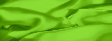 Yumuşak kıvrımları olan bulanık neon yeşil saten kumaş ve pürüzsüz ve parlak bir yüzey sunuyor. Kumaş ışığı yakalıyor, onu moda ve iç tasarım için mükemmel hale getiriyor.