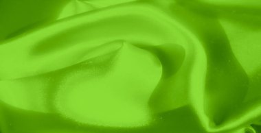 Yumuşak, sıvı kıvrımlı parlak yeşil saten kumaş ve parlak bir görünüş. Kumaşın lüks, ipeksi dokusu ışığı çok güzel yakalıyor.