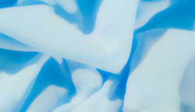 Pürüzsüz, açık mavi kumaş, akışkan çizgiler ve yumuşak dokularla kaplanmış. Soyut kıvrımlar bir hareket ve zarafet hissi yaratıyor, lüks görünümünü arttırıyor..