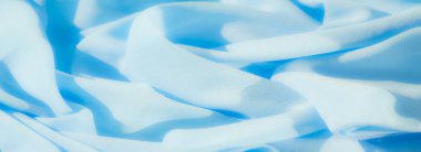 Yumuşak, dalgalı mavi kumaşı bulanıklaştırır, narin dokusunu ve kıvrımlarını yakalar. Pürüzsüz malzeme, sakin arka planlar ve soyut tasarımlar için mükemmel, uyumlu ve rahatlatıcı bir görsel yaratıyor..