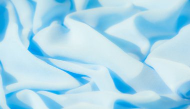 Yumuşak, dalgalı mavi kumaşı bulanıklaştırır, narin dokusunu ve kıvrımlarını yakalar. Pürüzsüz malzeme, sakin arka planlar ve soyut tasarımlar için mükemmel, uyumlu ve rahatlatıcı bir görsel yaratıyor..