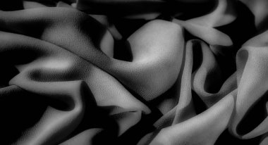 Gri tonlu kumaşın yumuşak dokusu gölgeler ve katlar oyunuyla geliştirilir, pürüzsüz eğriler ve rafine kumaş ayrıntılarıyla sakin ve zarif bir görüntü yaratır..