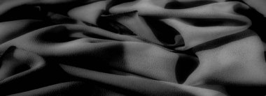 Pürüzsüz kıvrımları ve yumuşak gölgeleri olan sakin gri tonlu bir kumaş. Zarif bir ışık ve doku oyunu, kumaşın inceliğini ve zarafetini arttırır..