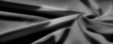 Siyah, gri tonda kıvrımlı dalgalı kumaşlar. Yumuşak dokuyu pürüzsüz bir çizgi akışıyla gösteriyor. Aydınlık ve karanlık tonlar arasındaki oyun minimalist bir estetik ile büyüleyici bir görsel yaratıyor..
