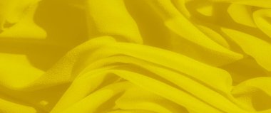 Bulanık sarı kumaş dalgaları karmaşık kıvrımlar ve kıvrımlar sergiliyor. Zengin kumaş dokusu ışığı yakalar ve parlak yüzeyinde dinamik zıtlıklar yaratır..