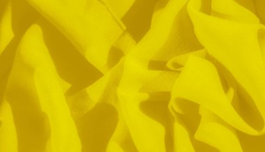 Bulanık sarı kumaş dalgaları karmaşık kıvrımlar ve kıvrımlar sergiliyor. Zengin kumaş dokusu ışığı yakalar ve parlak yüzeyinde dinamik zıtlıklar yaratır..